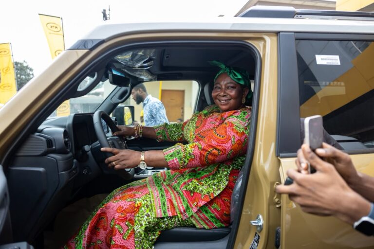 Winner Faustina Asante smiles behind the steering wheel of her new vehicle