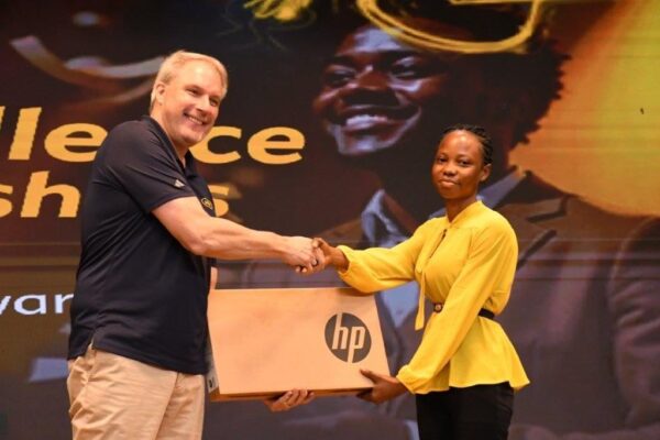 Stephen Blewett, CEO of MTN Ghana presenting a laptop to one of the beneficiaries